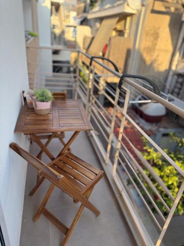a small wooden table and chairs on a balcony at Light & kozy apartment in Patra