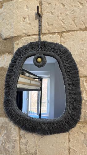 a tire mirror hanging on a brick wall at Séjour de charme, Notre-Dame, Hypercentre in Saint-Quentin