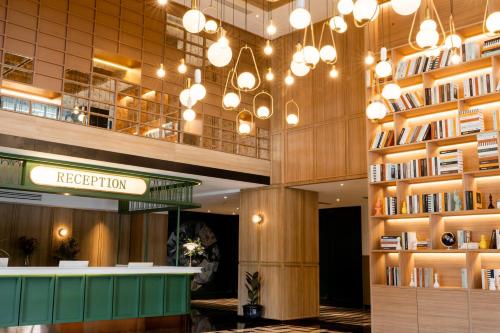 a lobby with a library with books on shelves at Graph Hotels Bangkok in Bangkok