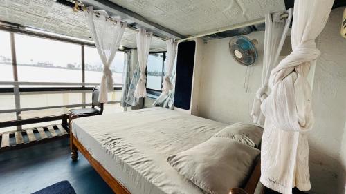 a bedroom with a canopy bed in a room with a window at Coral Reef Malpe - Udupi in Udiyāvara