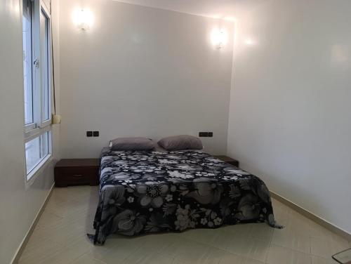 una camera da letto con un letto con una coperta bianca e nera di familial simple pratique ad Agadir