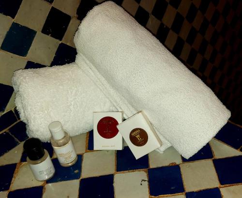 a pile of towels and cosmetics on a bathroom floor at Palais AL Firdaous in Fès