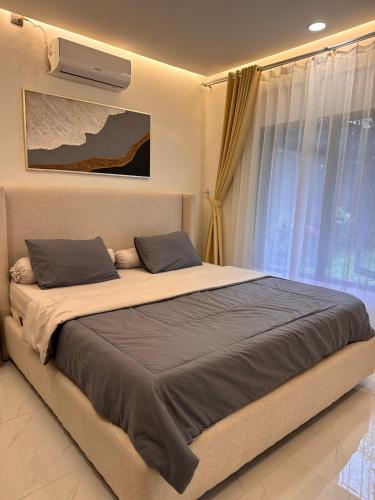 a bed with two pillows in a bedroom with a window at Villa TUWAIQ 1 فيلا طويق بونشاك in Sampal 2