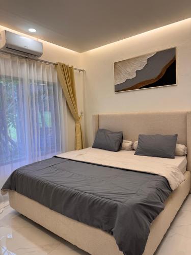 a large bed in a bedroom with a window at Villa TUWAIQ 1 فيلا طويق بونشاك in Sampal 2