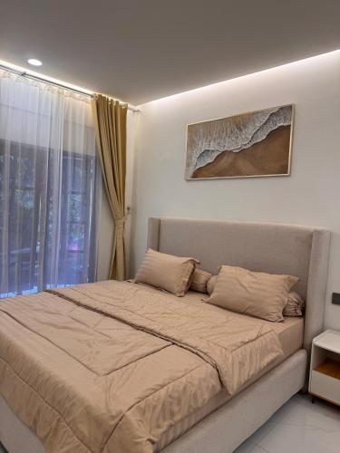 a large bed in a bedroom with a window at Villa TUWAIQ 1 فيلا طويق بونشاك in Sampal 2