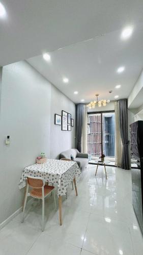 a living room with a table and a couch at Masteri An Phu - Condo 1-2BR Apartment with Pool GYM D2 in Ho Chi Minh City