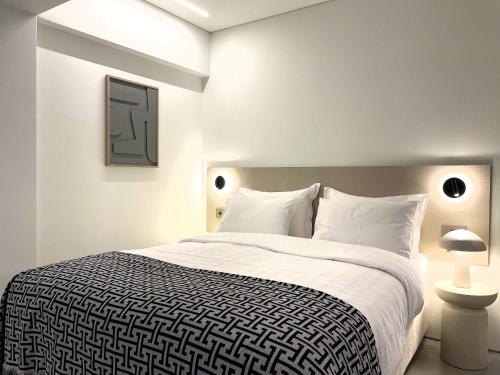 a white bedroom with a large bed with white pillows at THE NIXON Luxury Suites and Apartment Hotel in Athens