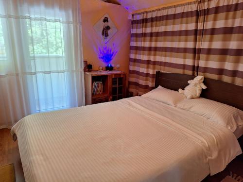 a bedroom with a bed with a teddy bear on it at Casa Delia in Balta