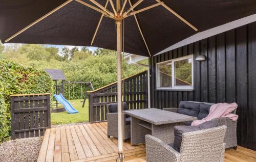 a patio with a table and chairs and an umbrella at Nice Home In Ebeltoft With Sauna in Ebeltoft