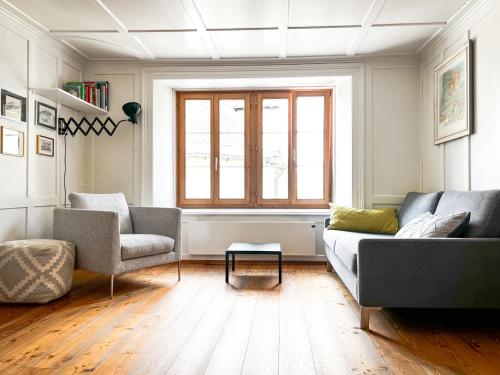 a living room with a couch and two chairs at Grosshus Vals in Vals