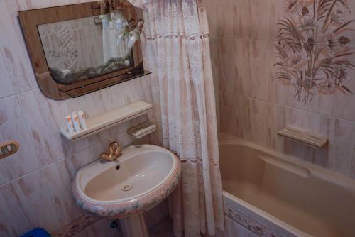a bathroom with a sink and a mirror and a tub at Andalusia Blue Beach Hurghada in Hurghada