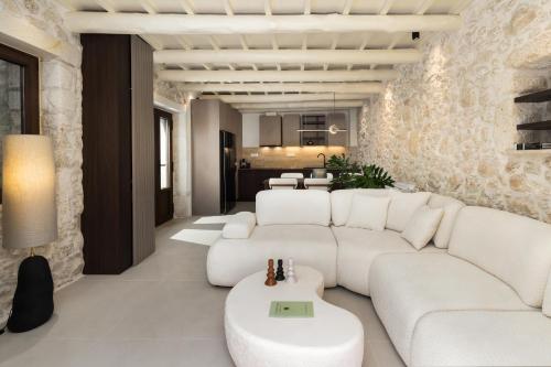 a living room with a white couch and a table at Vernardo's Heritage by Nest in Gerani