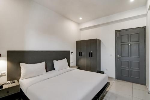 a bedroom with a large white bed and a door at Townhouse South City 2 Sector 49 Gurgaon in Gurgaon