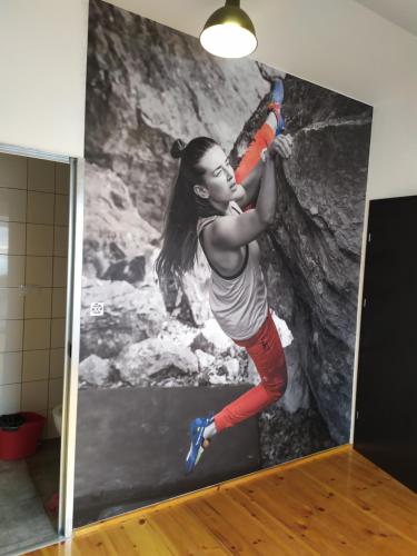 a woman climbing a rock wall in a room at Trafo Base Camp in Kroczyce