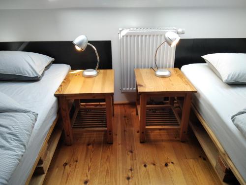 two beds in a room with two lamps on tables at Trafo Base Camp in Kroczyce