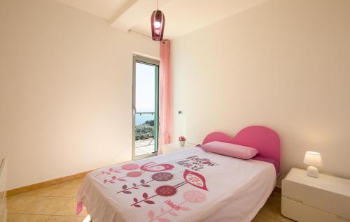 a bedroom with a bed with a pink headboard and a window at Amazing Home In Belmonte Calabro in Belmonte Calabro
