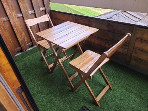- 2 chaises en bois et une table sur une terrasse couverte dans l'établissement Studio 4 pers. quartier de l'Eclose - maeva Home - Studio 4 Personnes - Confort MAE-7057, à L'Alpe-d'Huez