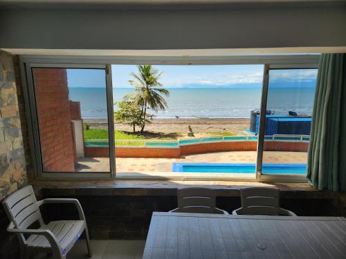 a room with a view of the beach from a window at TUCACAS VISTA Y SALIDA AL MAR Apto TIPO ESTUDIO DUPLEX SIN HABITACIÓN INDEPENDIENTE in Tucacas