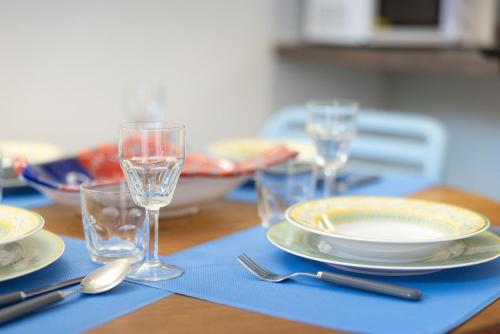 a table with plates and glasses on a blue napkin at Casa Azzura Bilocale chic a due passi dal Duomo in Pinerolo