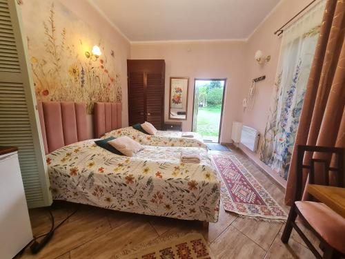 a bedroom with two beds and a door to a yard at Pensjonacik Ogrody in Pierzchno