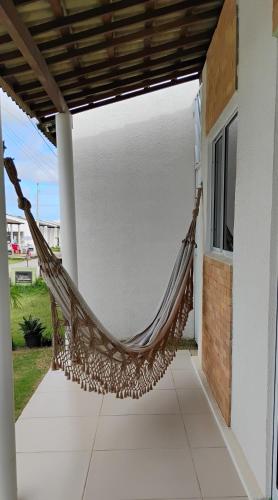 a hammock on a porch of a house at Quarto 8km Aeroporto de Maceió in Maceió