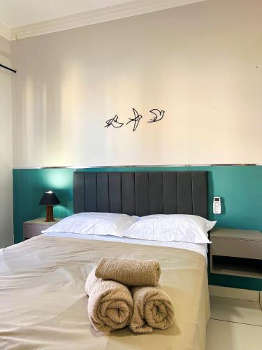 a bedroom with a bed with three birds on the wall at Apê-202 |Ar, Garagem, Suíte | Unipam e Parque Expo in Patos de Minas