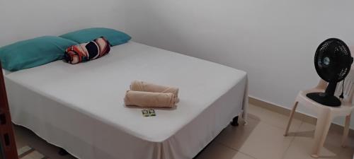 a white bed with a pillow and a towel on it at Quarto 8km Aeroporto de Maceió in Maceió