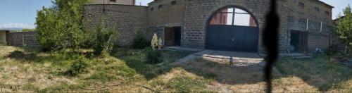 a brick building with a door and a yard at Welcome to Ashtarak in Ashtarak