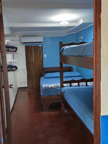 a room with three bunk beds and a door at Congos Hostal y Camping in Playa Hermosa