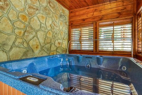 a large blue tub in a room with a stone wall at Grand Lodge in Sevierville