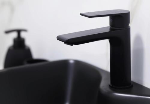 a bathroom sink with a black faucet at Apartment Simply 205 in Gázion