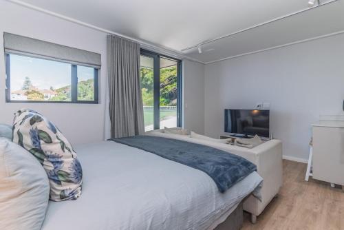 a bedroom with a large bed and a large window at Stylish Studio with Ocean Views at Wavescapes in Muizenberg