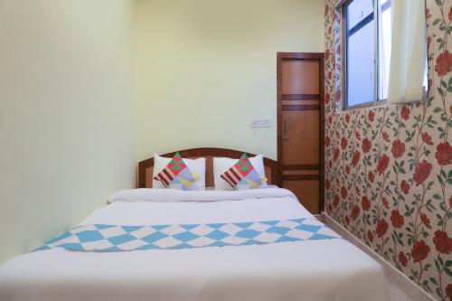 a bedroom with two beds and a window at Hotel O Home Cozy Studio Collage Square Hotel Maya International Near St. Thomas's Church in Kolkata