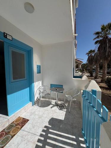 a patio with chairs and a table and a blue door at Murdeira V17 RC by RPG Group in Beirona