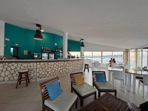 a restaurant with chairs and a bar with the ocean at Murdeira V17 RC by RPG Group in Beirona