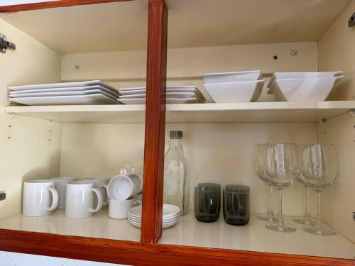 a cabinet filled with plates and glasses and dishes at Murdeira V17 RC by RPG Group in Beirona