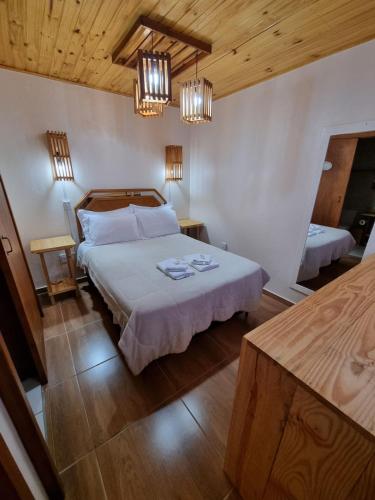 a bedroom with a bed in a room with wooden ceilings at Pousada Alternativa KeKe in Urubici