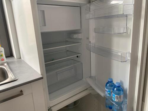 an empty refrigerator with two bottles of water in it at Apartament Zoom 42 in Bydgoszcz