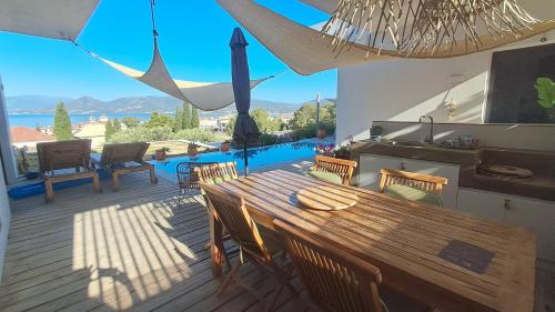 a wooden table and chairs on a deck with a view at Villa Karma in Paleros