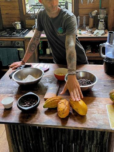 a man standing in a kitchen preparing food on a counter at Finca La Selvita Chocolate experience in Buritaca