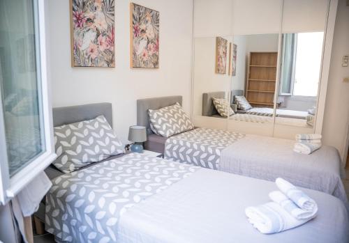 Cette chambre comprend 2 lits et un miroir. dans l'établissement Charmant 4 pièces - Cour privative - Port de Nice, à Nice