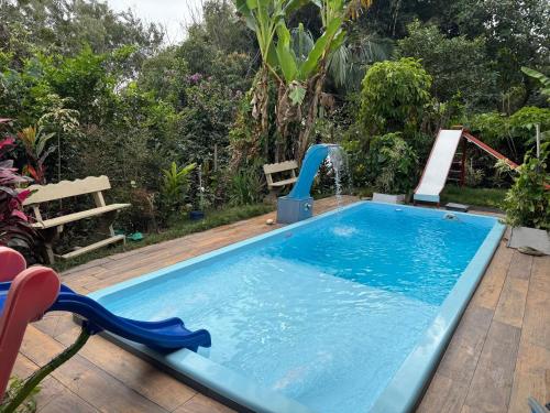 a pool with a water fountain in a yard at Chácara Nhá Chica - Roseira - Aparecida - a 8km do Santuário Nacional in Aparecida