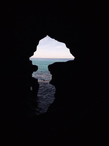 a dark cave with the ocean in the background at Diafa Stay in Tangier