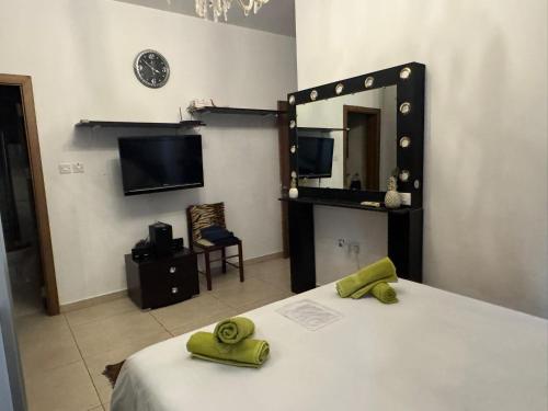 ein Schlafzimmer mit einem Spiegel und einem Bett mit grünen Handtüchern in der Unterkunft Stylish Sea view Apartment Feels Like Home, Just Steps from the Beach in Marsaskala