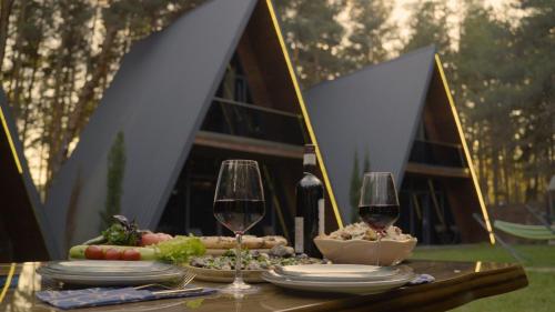 a table with glasses of wine and food on it at Park Hotel Surami Chalet in Surami