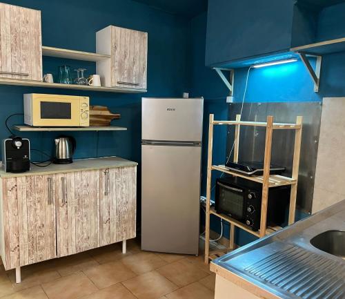 La cuisine est équipée d'un réfrigérateur blanc et d'un four micro-ondes. dans l'établissement Cosy Studio proche Lac Salagou, à Clermont-lʼHérault