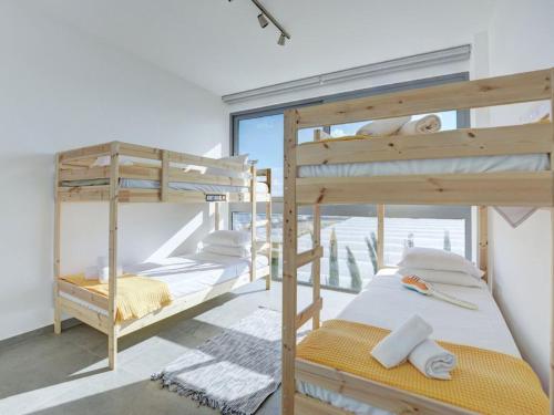 due letti a castello in una stanza con finestra di Villa Limni Dyo - Luxurious Contemporary 3 Bedroom Villa With Sea Views And Hot Tub a Paralimni