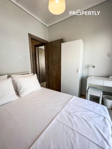 a large white bed in a room with a sink at Blue Seaview Apartment #PROPERTLY in Nea Kalikratia