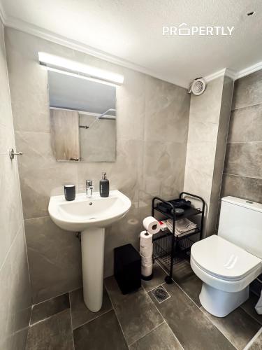 a bathroom with a white sink and a toilet at Blue Seaview Apartment #PROPERTLY in Nea Kalikratia