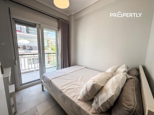 a small bedroom with a bed and a window at Blue Seaview Apartment #PROPERTLY in Nea Kalikratia